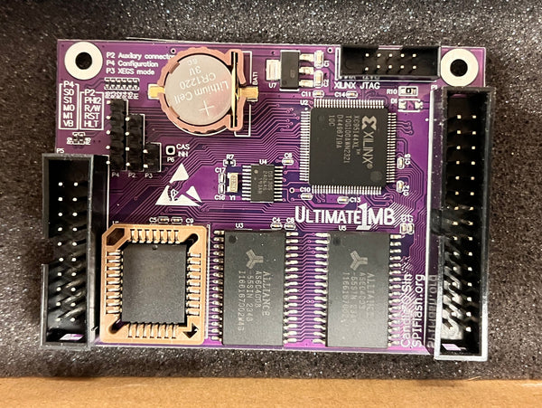 Purple electronic circuit board on a textured surface with books in the background